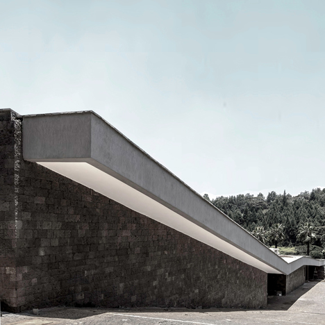 Hewn sandstone walls and an overhanging roof enclose a hillside home in Nairobi