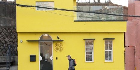 Seoul fashion boutique features yellow walls and an Eames bird above the entrance