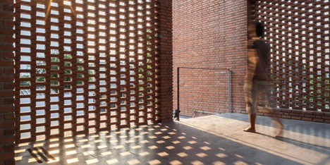 Brick grates set into the walls of a Bangkok house hide a series of outdoor spaces