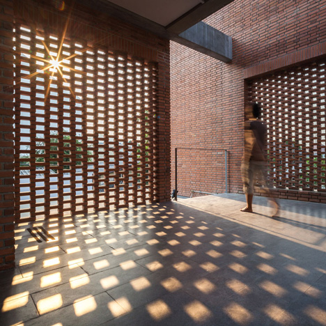 Brick grates set into the walls of a Bangkok house hide a series of outdoor spaces