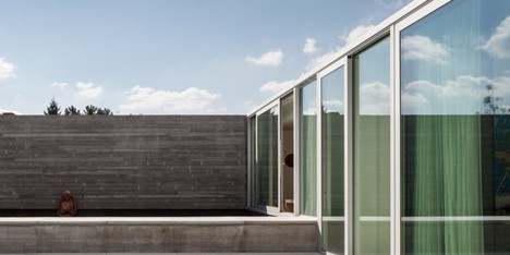 Concrete and glass extension to Belgian house shelters a poolside patio
