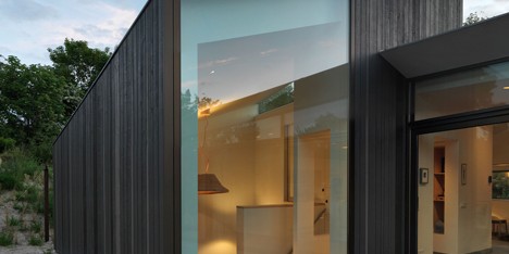 Larch-clad holiday home by De Zwarte Hond huddles behind the dunes on a Dutch island