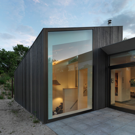 Larch-clad holiday home by De Zwarte Hond huddles behind the dunes on a Dutch island
