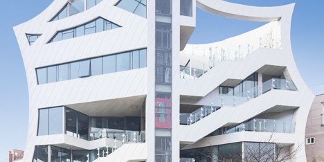 Concave walls give a scalloped outline to mixed-use block by Iroje KHM Architects