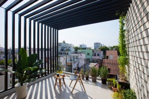 Townhouse with a folding-up shutter in Vietnam by MM++ Architects