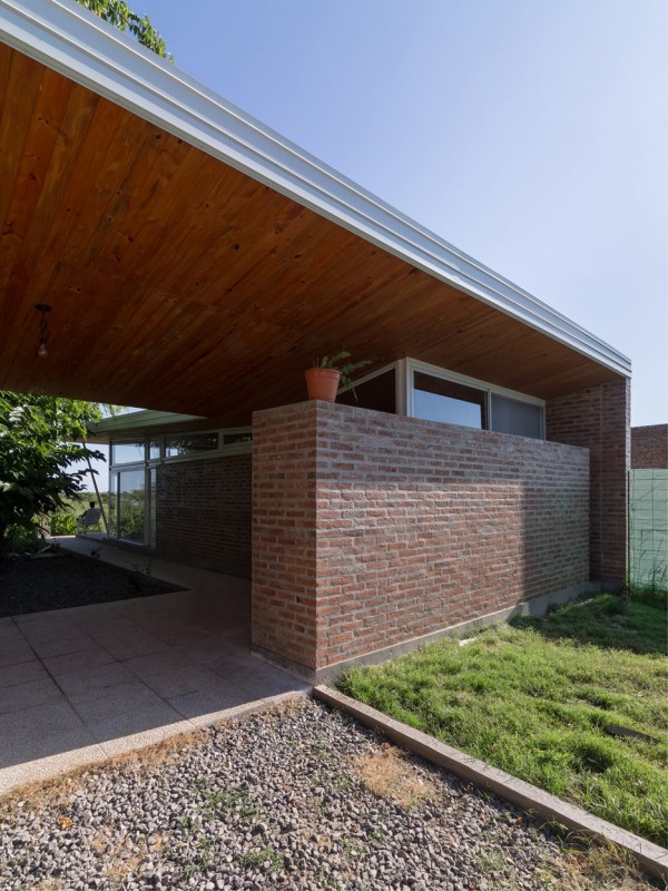 House 50 50 by Celula Urbana sits next to a river in Argentina