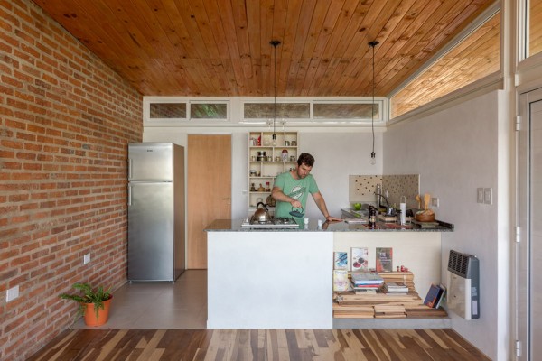 House 50 50 by Celula Urbana sits next to a river in Argentina