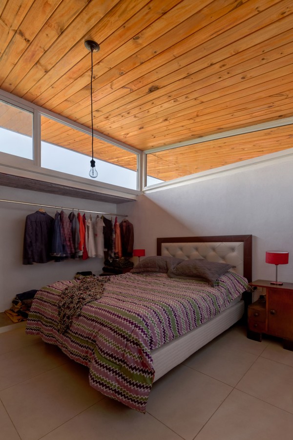House 50 50 by Celula Urbana sits next to a river in Argentina