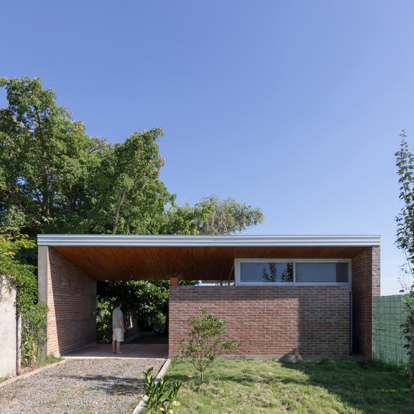 House 50 50 by Celula Urbana sits next to a river in Argentina