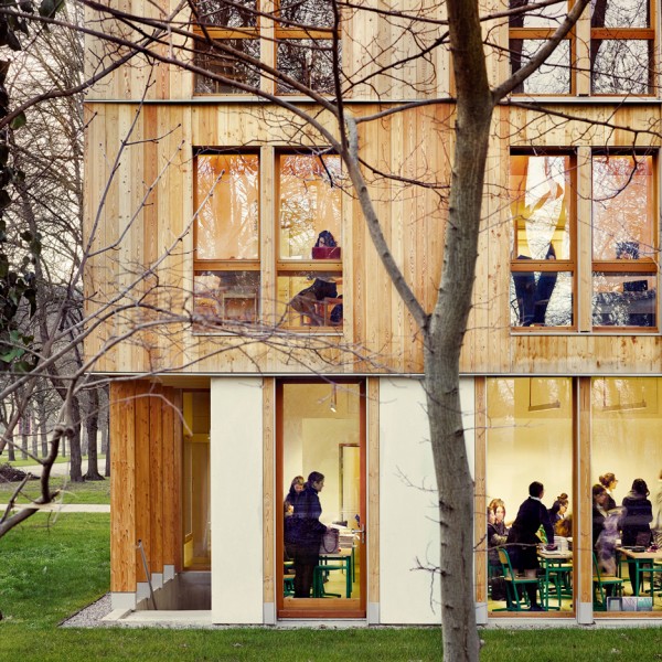 Timber and glass dormitory building nestles among trees in a Paris park