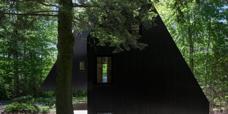 Jean Verville creates black fairytale-like cottage in a Quebec forest
