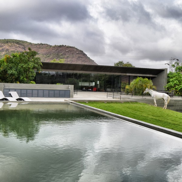 Spasm Architects clad Indian house in local stone and wrap it around a sunken courtyard.