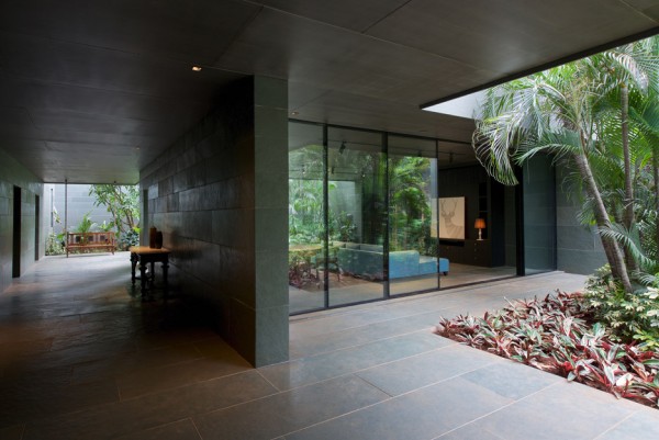 Spasm Architects clad Indian house in local stone and wrap it around a sunken courtyard.