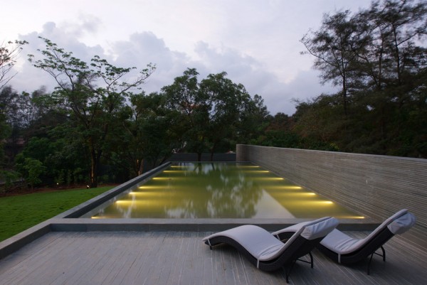 Spasm Architects clad Indian house in local stone and wrap it around a sunken courtyard.