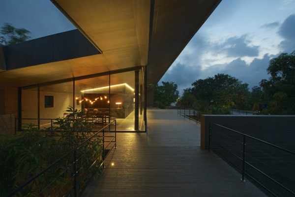 Spasm Architects clad Indian house in local stone and wrap it around a sunken courtyard.