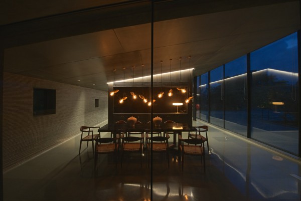 Spasm Architects clad Indian house in local stone and wrap it around a sunken courtyard.