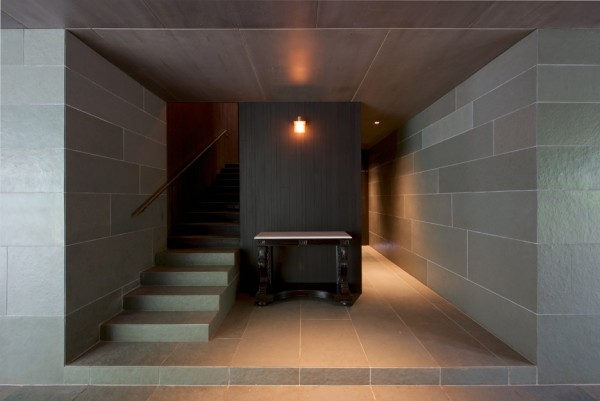 Spasm Architects clad Indian house in local stone and wrap it around a sunken courtyard.