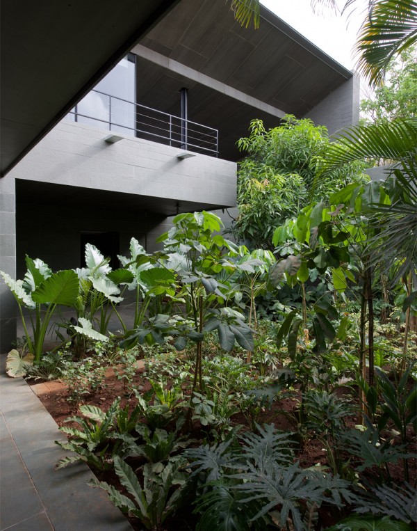 Spasm Architects clad Indian house in local stone and wrap it around a sunken courtyard.
