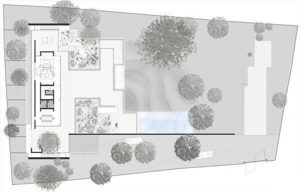 Spasm Architects clad Indian house in local stone and wrap it around a sunken courtyard.