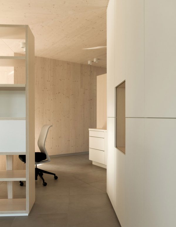 52 Kubik is an office building combining a mirrored base with a wooden upper floor