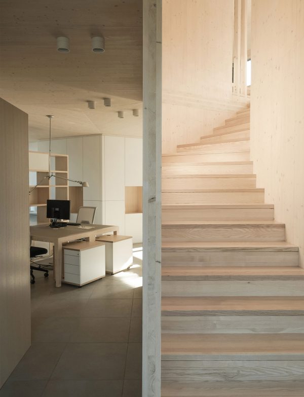 52 Kubik is an office building combining a mirrored base with a wooden upper floor
