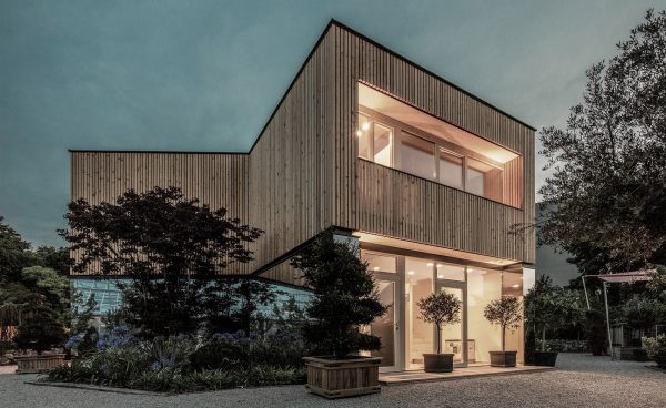 52 Kubik is an office building combining a mirrored base with a wooden upper floor