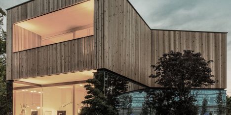 52 Kubik is an office building combining a mirrored base with a wooden upper floor