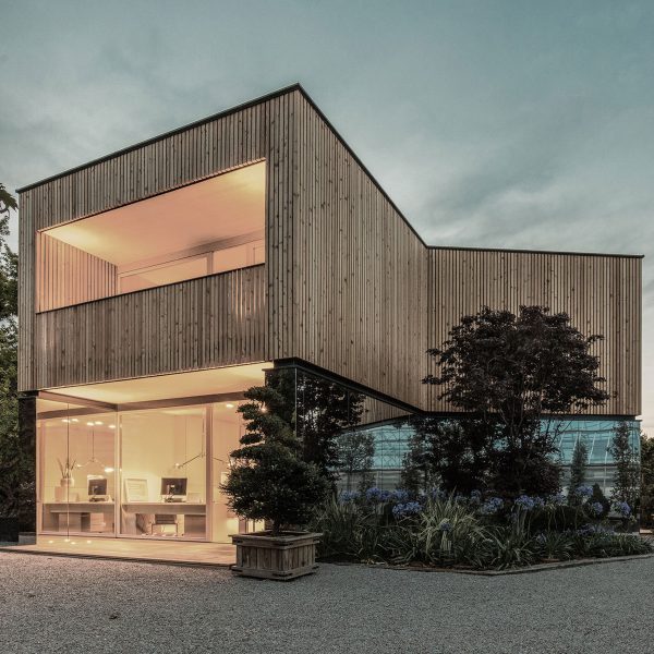 52 Kubik is an office building combining a mirrored base with a wooden upper floor
