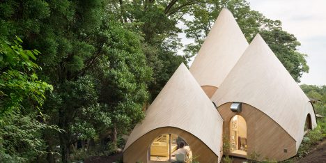 Teepee-shaped buildings by Issei Suma house community kitchen and spiral-shaped pool