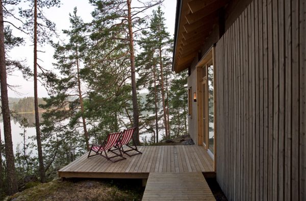 Lake cabin by Sini Kamppari features slatted timber siding and projecting terrace