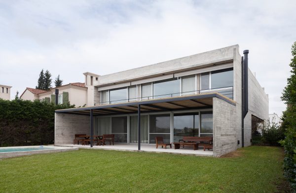 Textured concrete walls frame lake views from Buenos Aires house by Federico Sartor