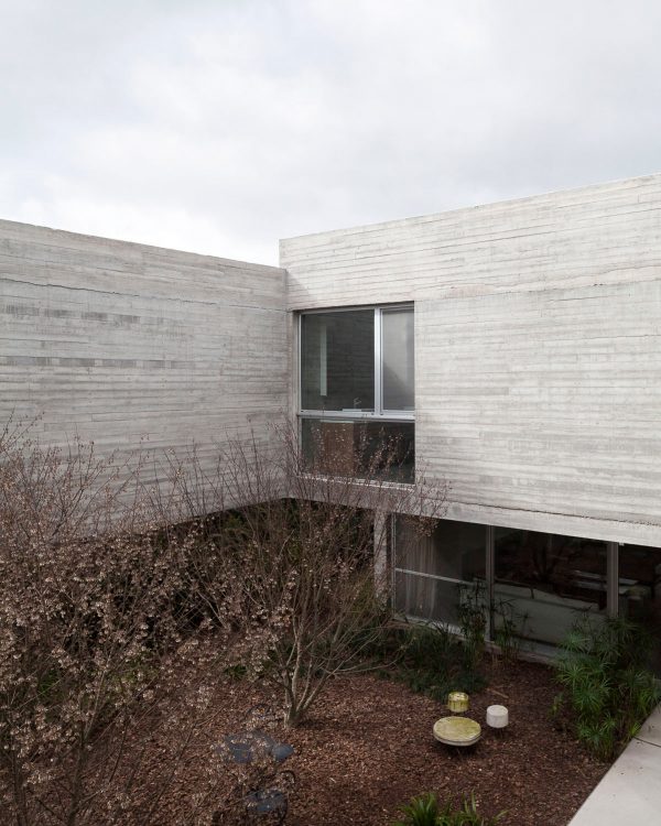 Textured concrete walls frame lake views from Buenos Aires house by Federico Sartor