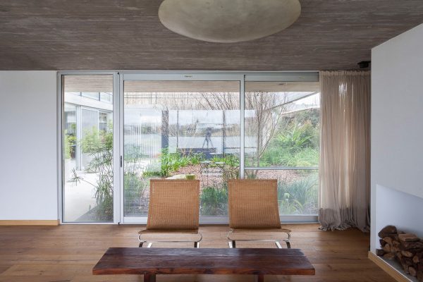 Textured concrete walls frame lake views from Buenos Aires house by Federico Sartor