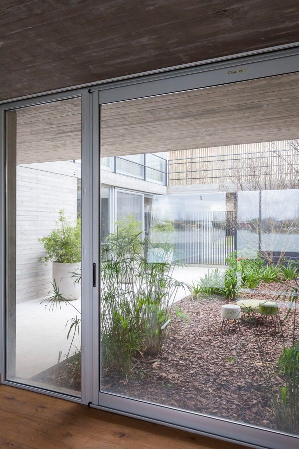 Textured concrete walls frame lake views from Buenos Aires house by Federico Sartor