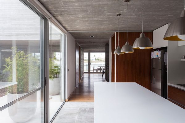 Textured concrete walls frame lake views from Buenos Aires house by Federico Sartor