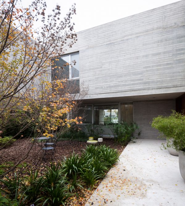 Textured concrete walls frame lake views from Buenos Aires house by Federico Sartor
