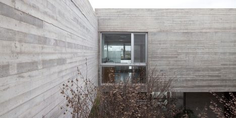 Textured concrete walls frame lake views from Buenos Aires house by Federico Sartor