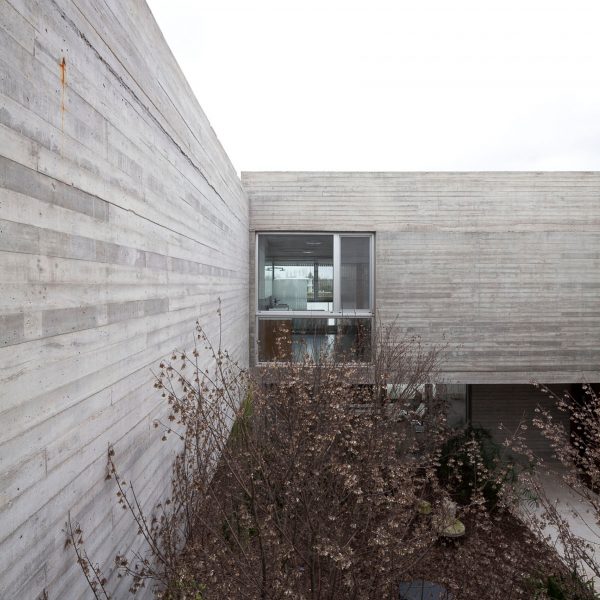Textured concrete walls frame lake views from Buenos Aires house by Federico Sartor
