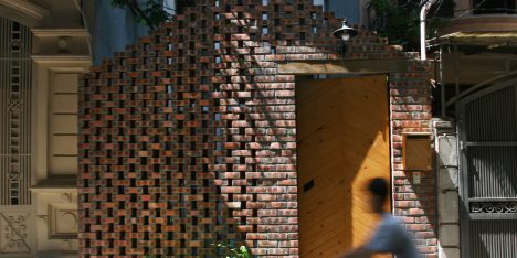 Perforated brick gable screens courtyard in front of compact Hanoi house