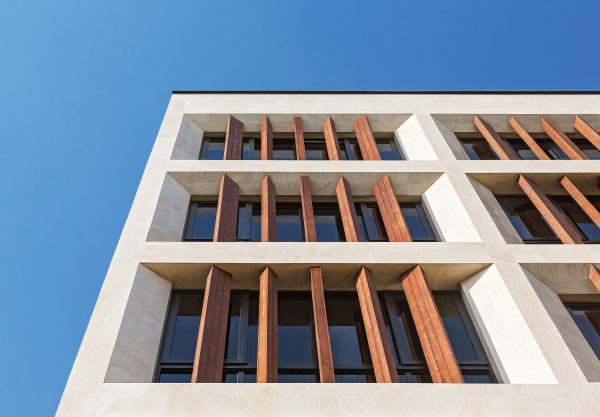 Tehran office building features facade divided into a grid of faceted window frames