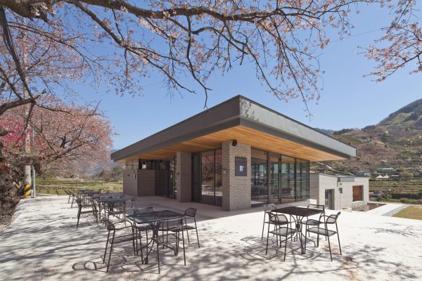 Rooftop bridge connects riverside house and roadside cafe in a South Korean valley