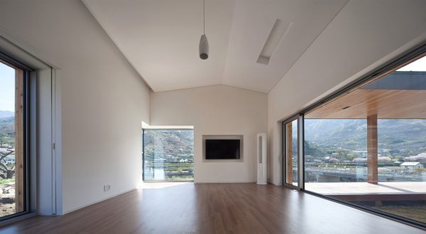 Rooftop bridge connects riverside house and roadside cafe in a South Korean valley