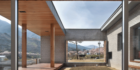 Rooftop bridge connects riverside house and roadside cafe in a South Korean valley