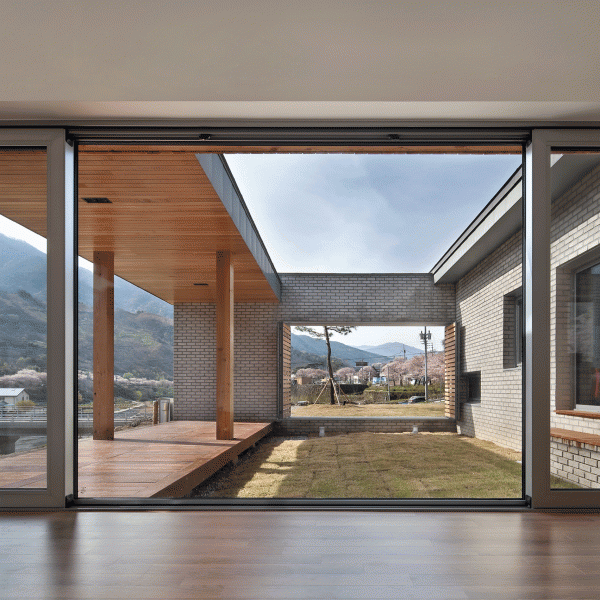 Rooftop bridge connects riverside house and roadside cafe in a South Korean valley