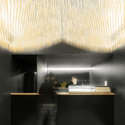 Paulo Merlini suspends chopsticks from ceiling of minimal sushi bar