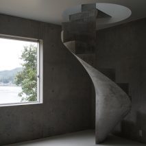 Chunky concrete staircase spirals through House in Akitsu by Kazunori Fujimoto