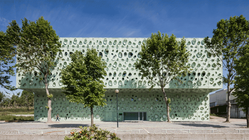 Perforated green cladding wraps university science institute by Cláudio Vilarinho
