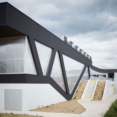 Diagonal columns create irregular windows for sports hall by Schemaa
