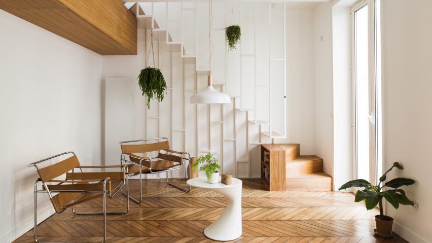 Paris apartment updated with slender white staircase and dark green kitchen