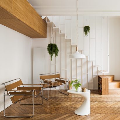Paris apartment updated with slender white staircase and dark green kitchen